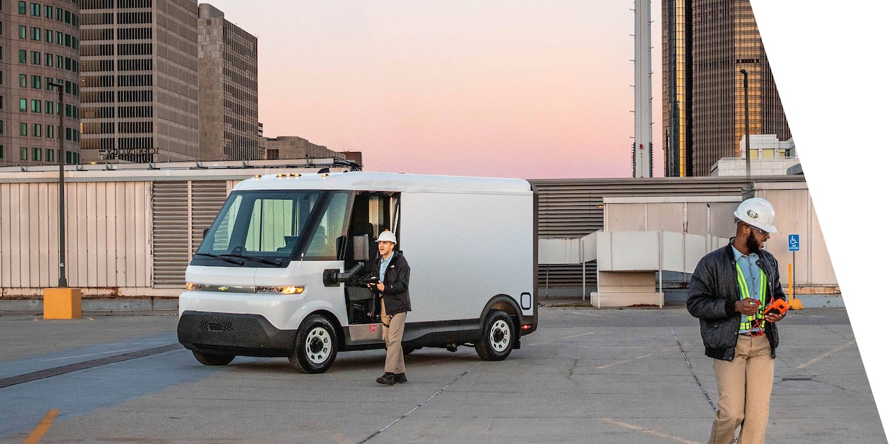 A Chevrolet BrightDrop on a job site. Two workers work nearby.