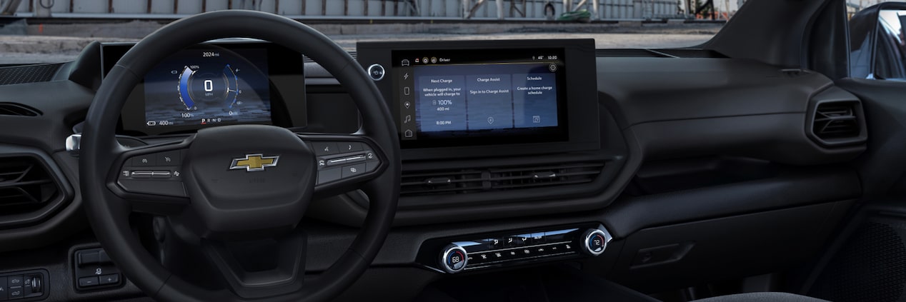 A full interior shot of the dashboard of a 2024 Silverado EV including the steering wheel, infotainment center, and passenger controls.