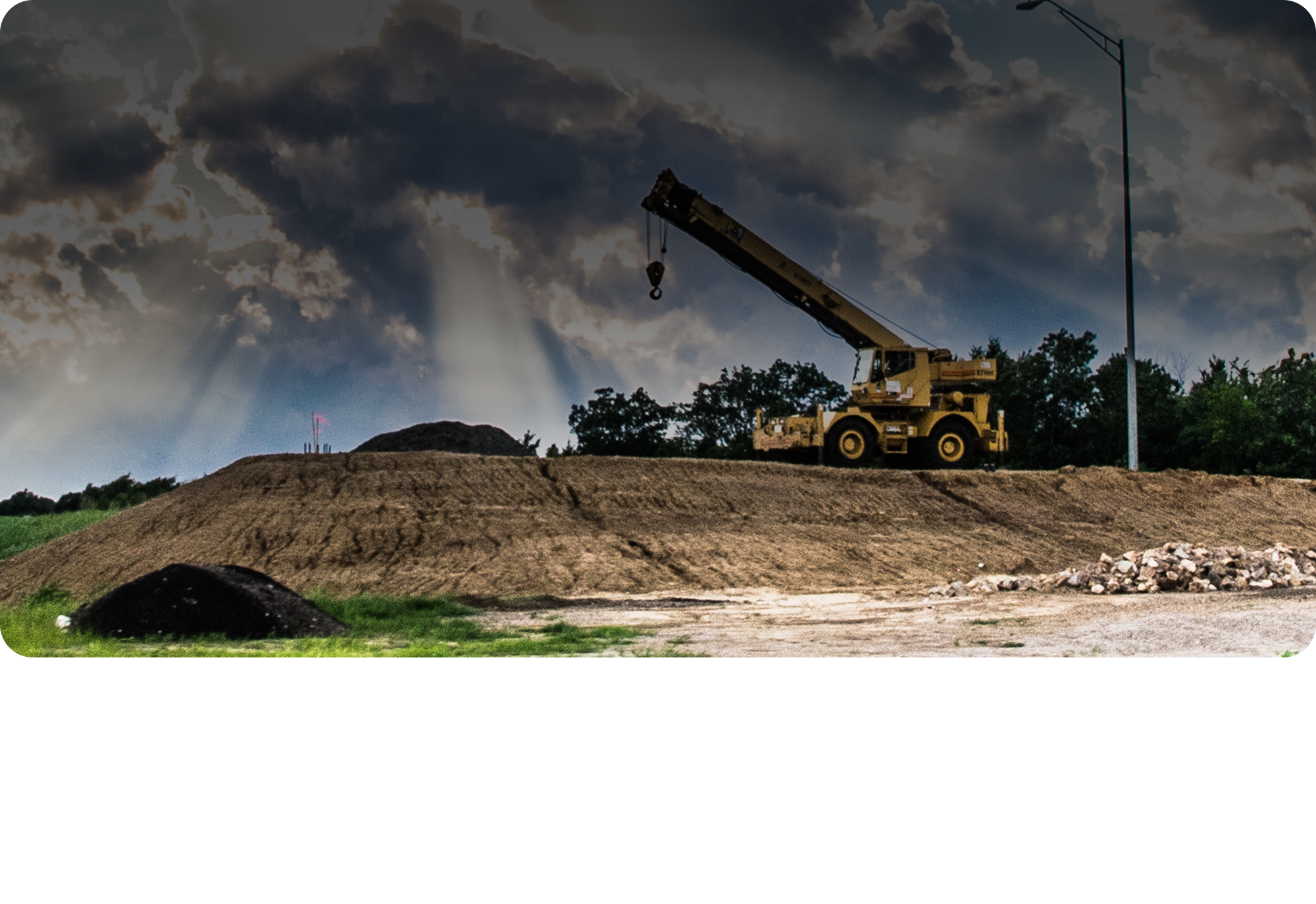 A construction site with a craine at the top of a hill