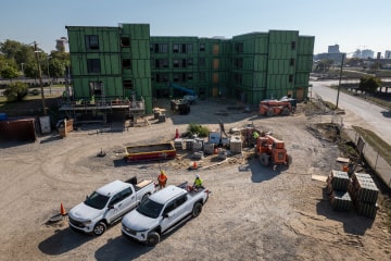 A skyview of a construction site with two Chevrolet Silverados parked.
