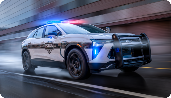A Chevrolet Blazer Police Protection Vehicle driving down a road with it's lights on