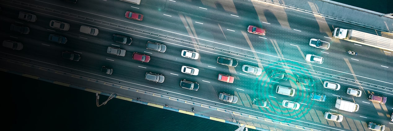 A sky view of a highway with a green ripple coming from a car that vehicle telematics.
