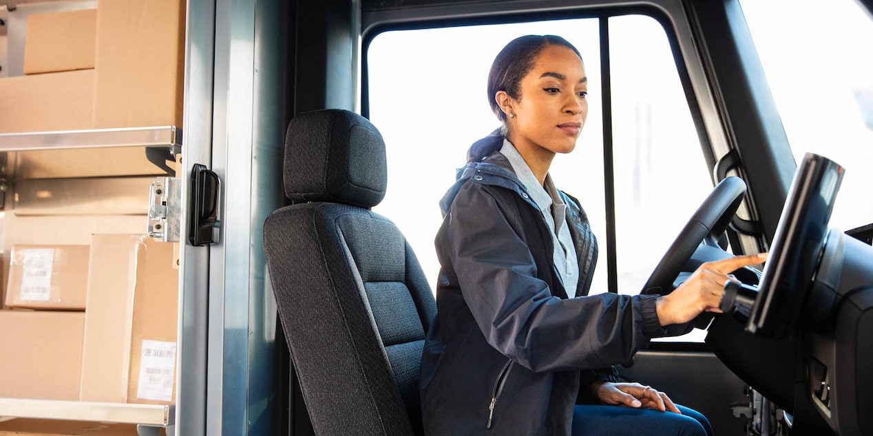 A driver using the touchscreen on a Chevrolet BrightDrop