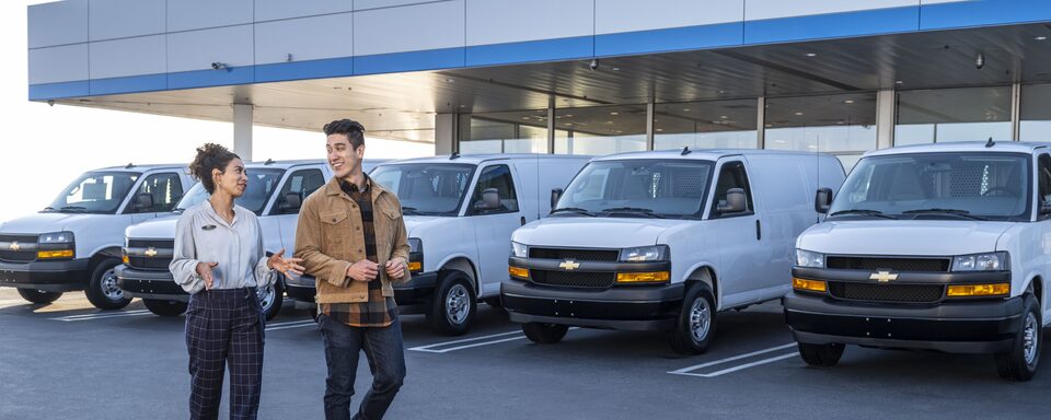 GM Fleet Dealer Speaking with Customer In Front of Fleet of Chevrolet Express Vans