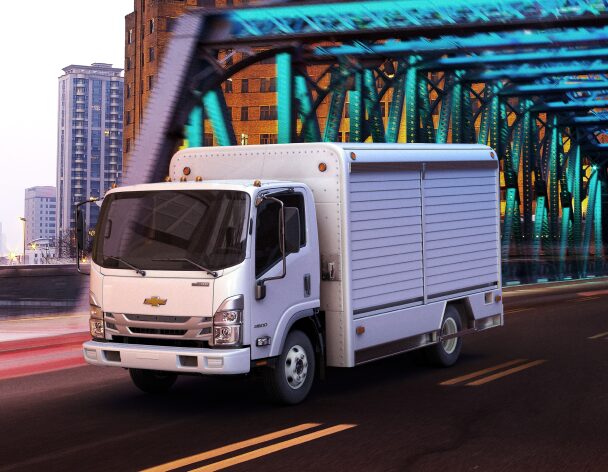 Three-Quarters Front View of the 2023 Chevrolet Low Cab Forward Truck Driving on a Bridge