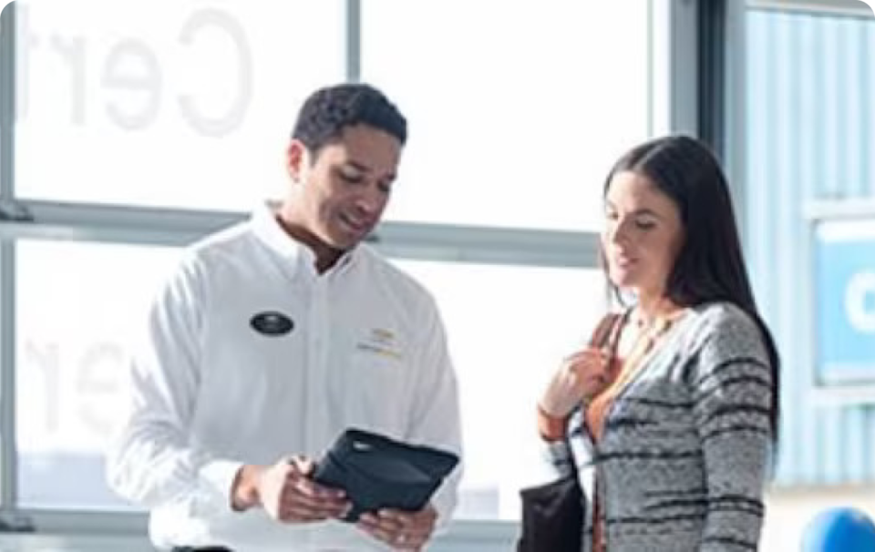 A Man Holding a Tablet Having a Discussion with a Woman
