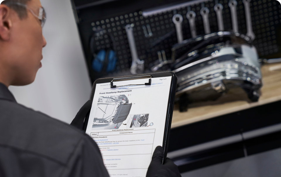 A GM Technician Reviewing Information on a Clipboard