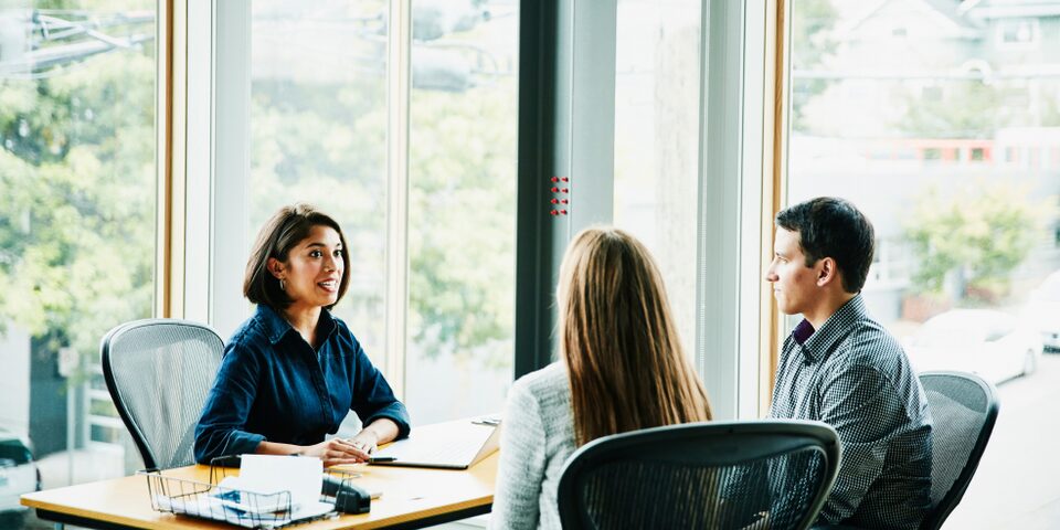 A Couple Sitting at a Table Having a Discussion with a Woman in Her Office