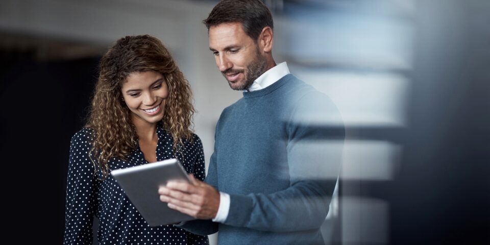 A Man and a Woman Looking at a Tablet Together