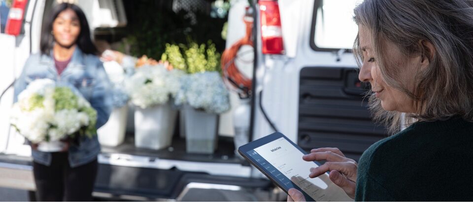 Woman using OnStar data services on tablet during flower delivery