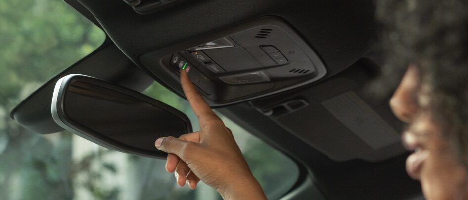 Woman pushing OnStar button in vehicle