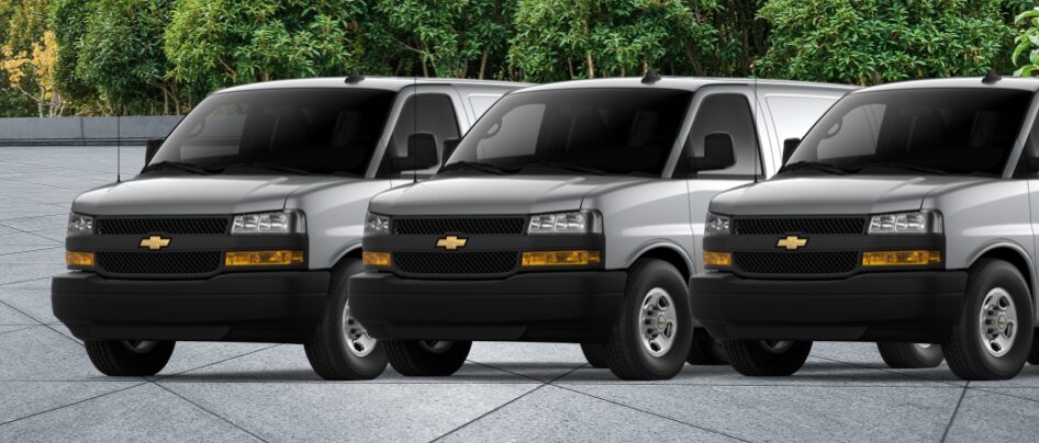 Three quarter View: Three Chevy Vans Parked Next To Each Other
