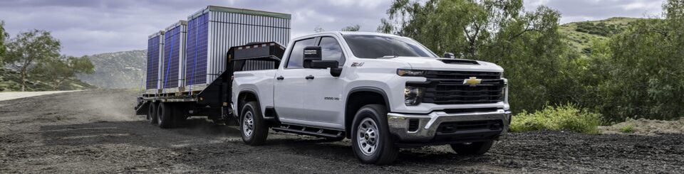 Three-Quarters Front View of the 2024 Chevrolet Silverado 2500 HD / 3500 HD Pulling a Trailer